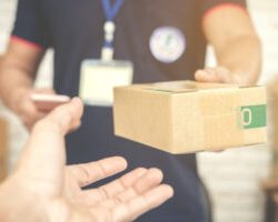 delivery-man-smiling-and-holding-cardboard-box delivery-man-smiling-and-holding-cardboard-box