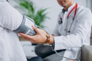 Young Male Psysician With Patient Measuring Blood Pressure Scaled E1618967948469